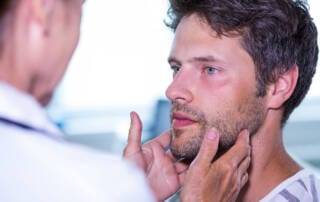 medico analisando a tireoide de paciente