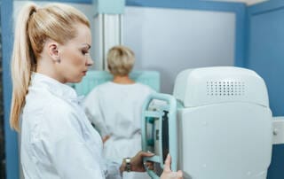 tecnica ajustando mamografo para realizar mamografia