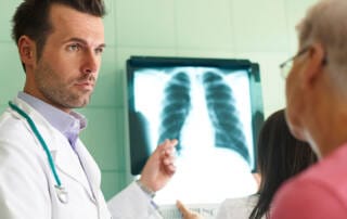 medico apresentando o exame de fibrose pulmonar