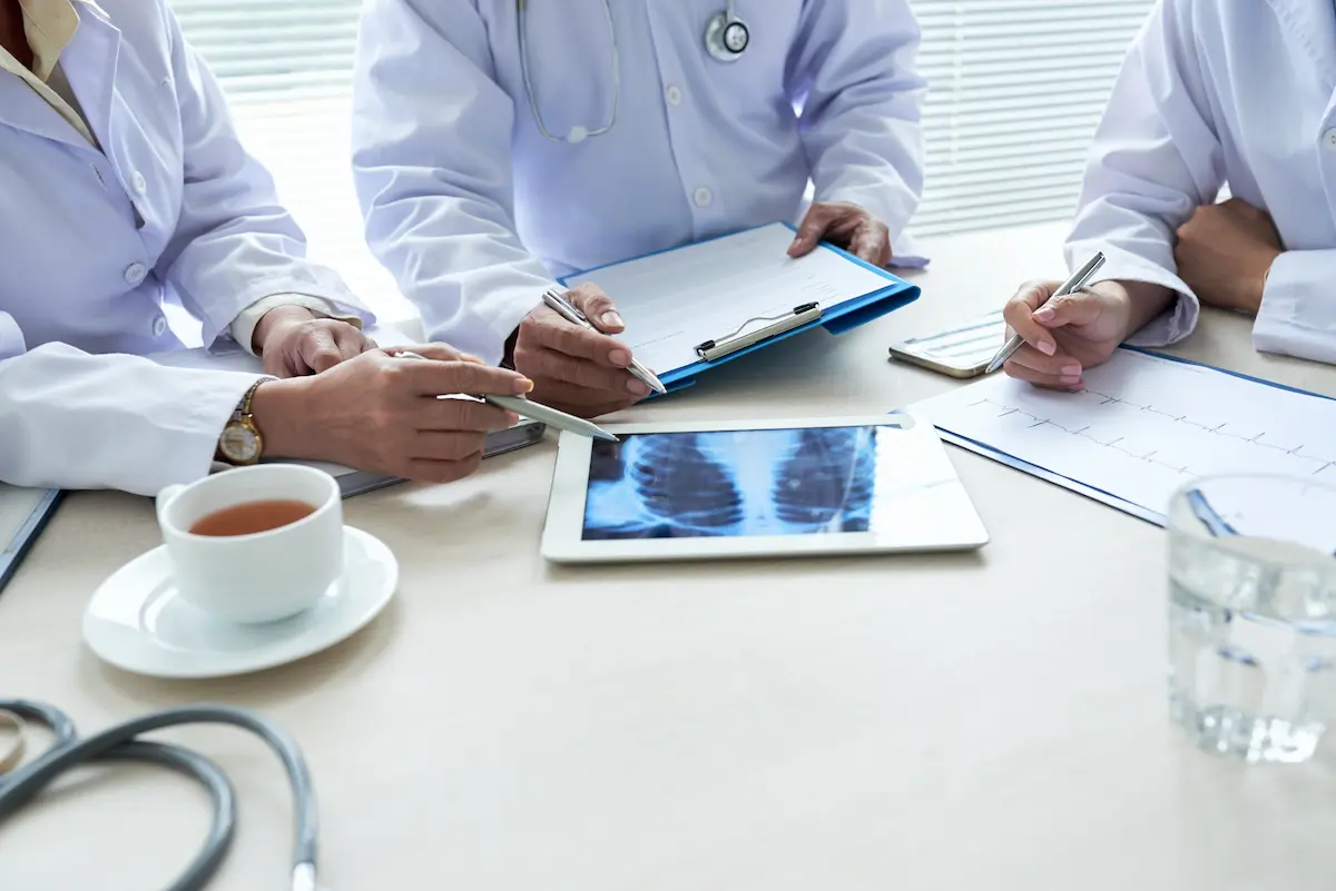 médicos debatendo sobre indicações clínicas após exames e teste de espirometria