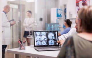 Médico mostra um exame com dados do paciente.