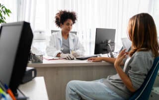 Médica realizando anamnese com paciente