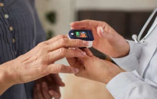 Médico utilizando oxímetro de pulso em uma consulta