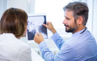 médico conversando sobre achados em exame com paciente durante a consulta
