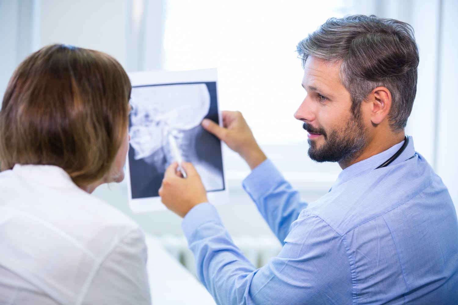 médico conversando sobre achados em exame com paciente durante a consulta
